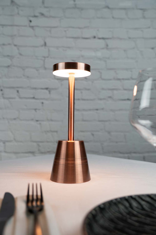 Copper round flat top cordless table lamp on restaurant table top