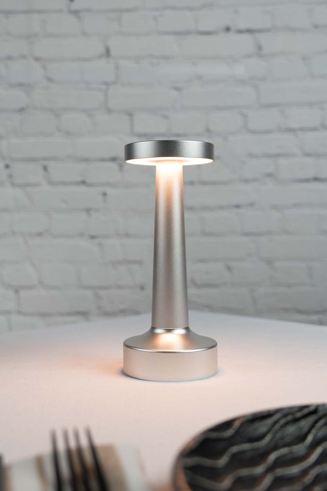 Silver flat top tapered cordless lamp on restaurant table top
