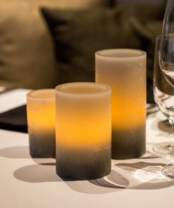 Set of Three Grey Wax Artisan Luminaries on Restaurant Table Top